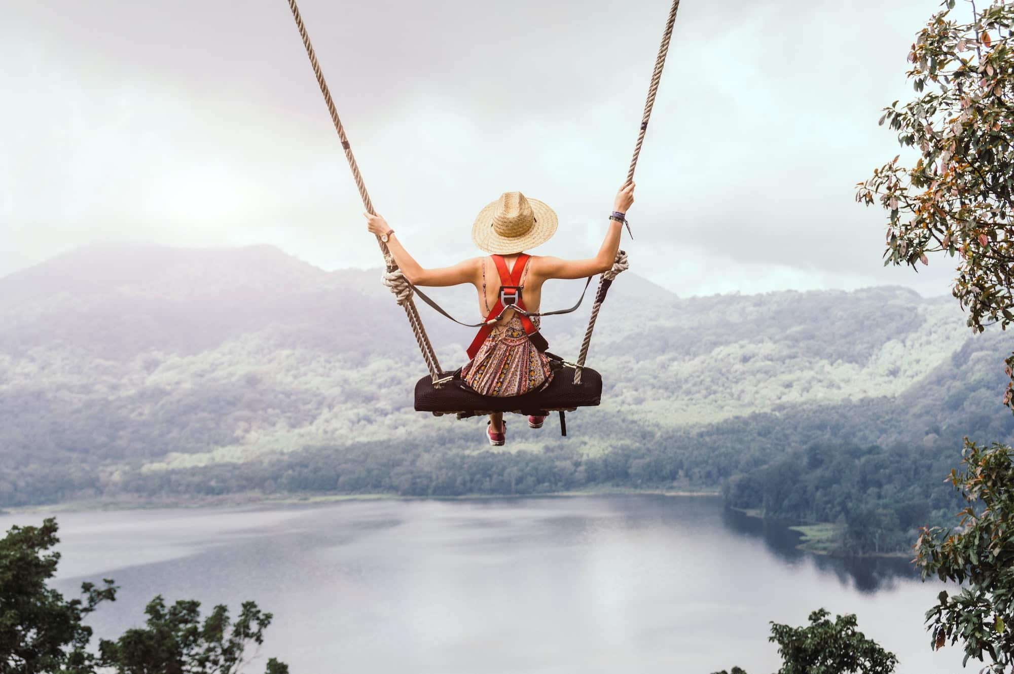 Beautiful girl enjoying freedom on swing in Bali, Indonesia