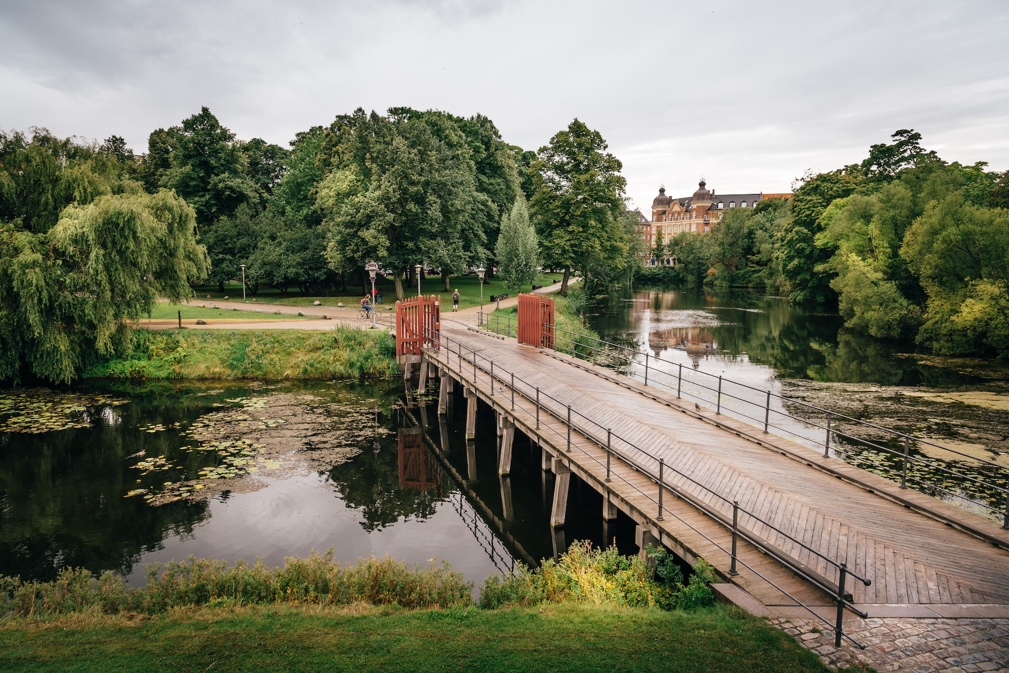 Bridge over pond in Churchill Park in Copenhagen, Denmark, a cloudy day of summer