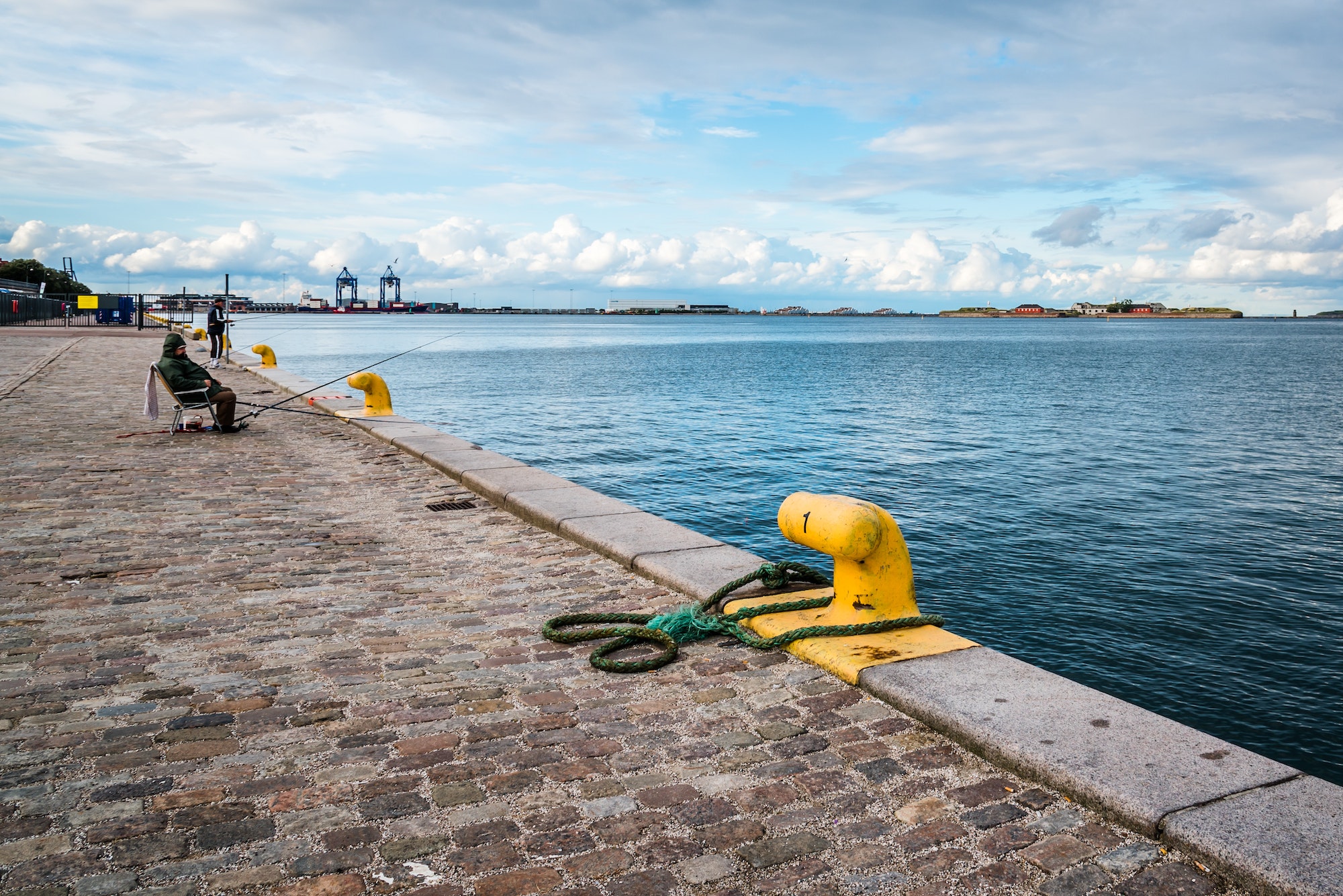 Fishermen fishing in the port of Copenhagen near sunset, Denmark.