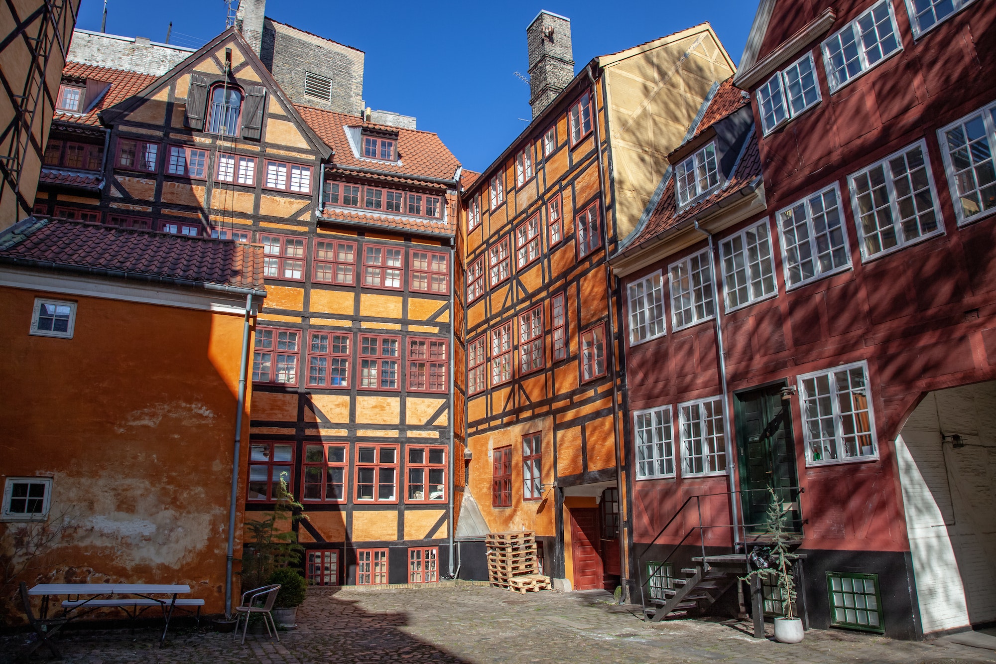 low angle view of beautiful historical houses against blue sky and cozy empty yard in copenhagen,