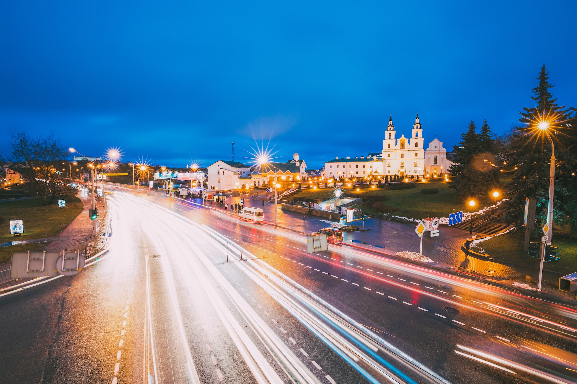 Minsk, Belarus. Night Traffic On Illuminated Street And Cathedr