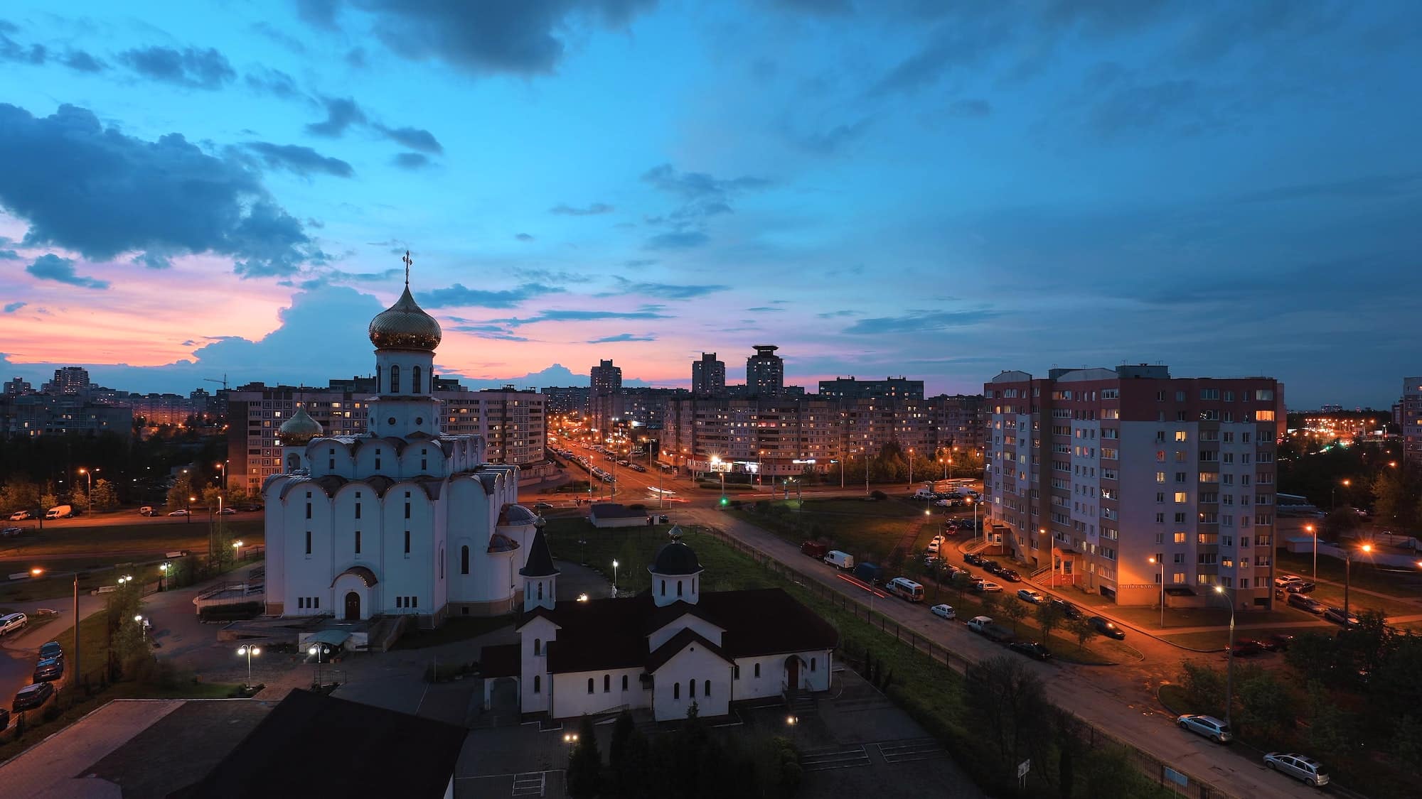 Traffic On Street And Multi-storey Residential Houses. Cityscape Minsk Skyline With Russian Orthodox