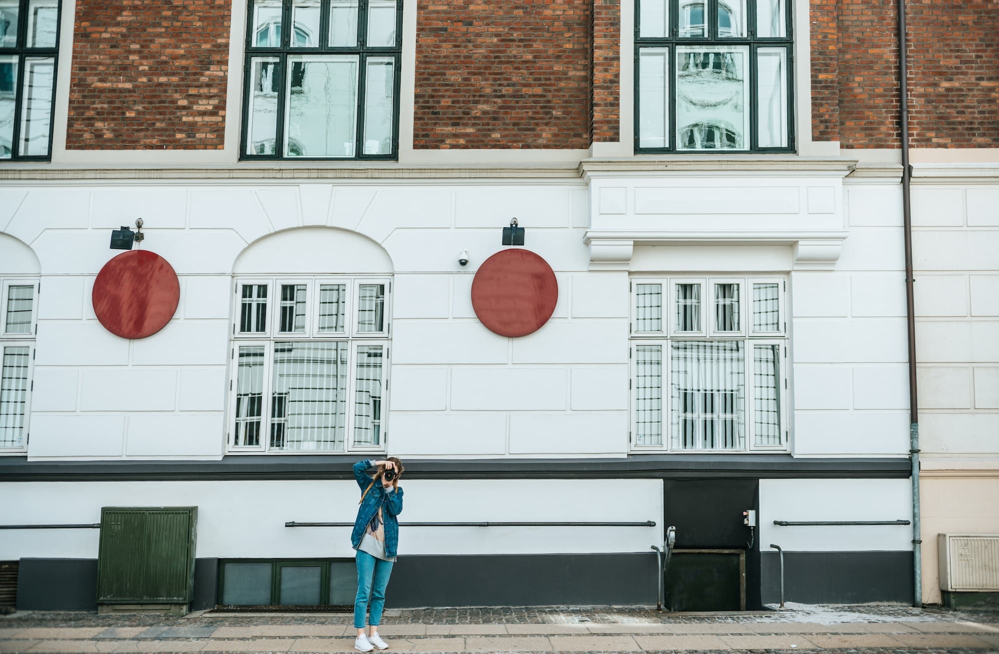 woman with photo camera taking picture on street in copenhagen, denmark