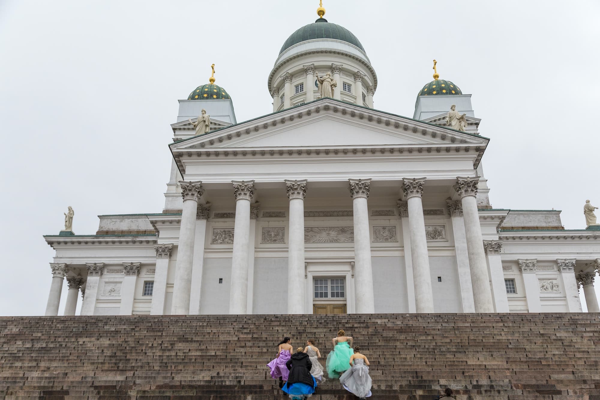 Women walking up the steps of the Lutheran Cathedral in Helsinki, Finland.