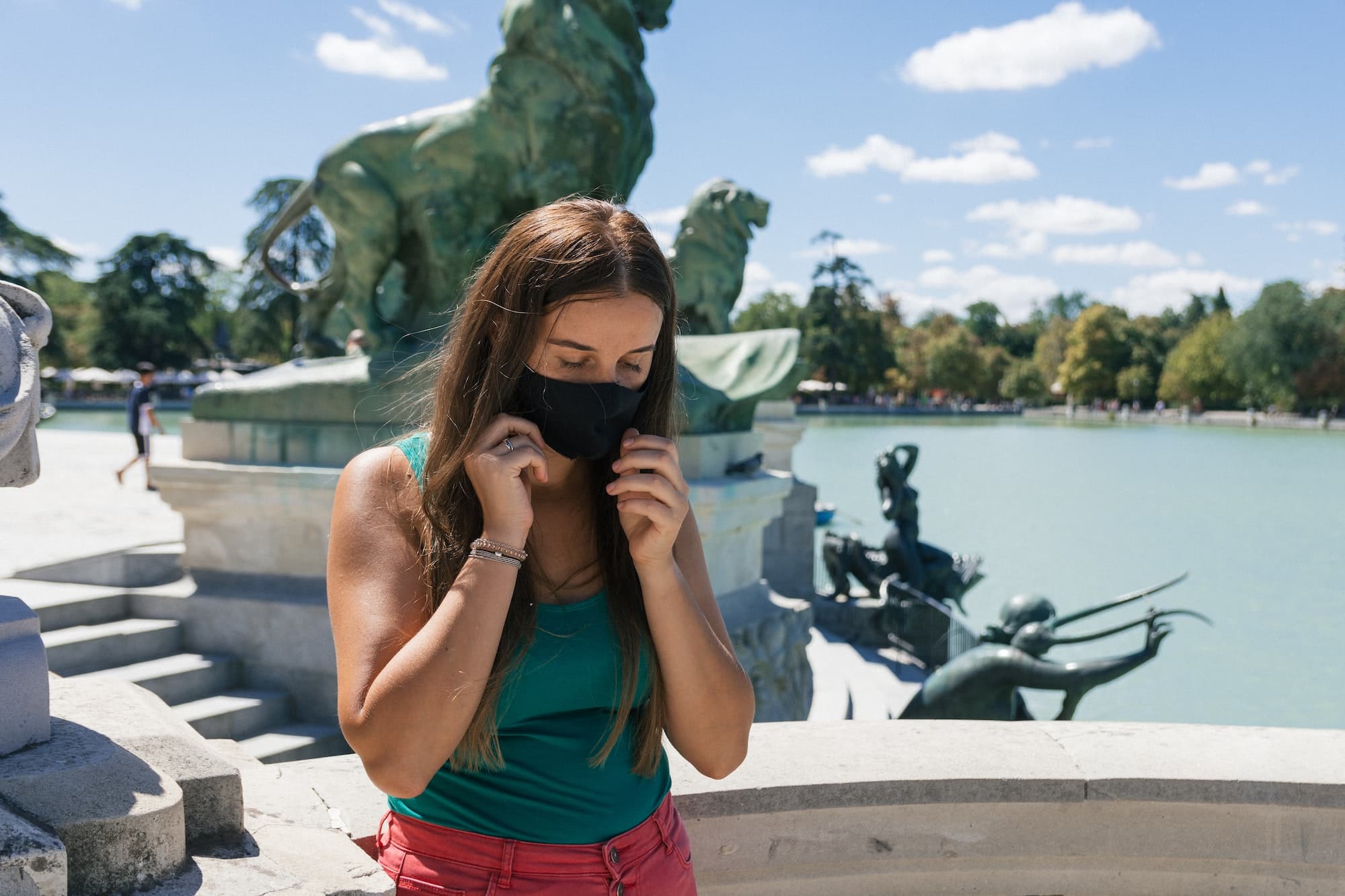 Young blonde woman wearing a protective mask against the virus at the Retiro Park in Madrid