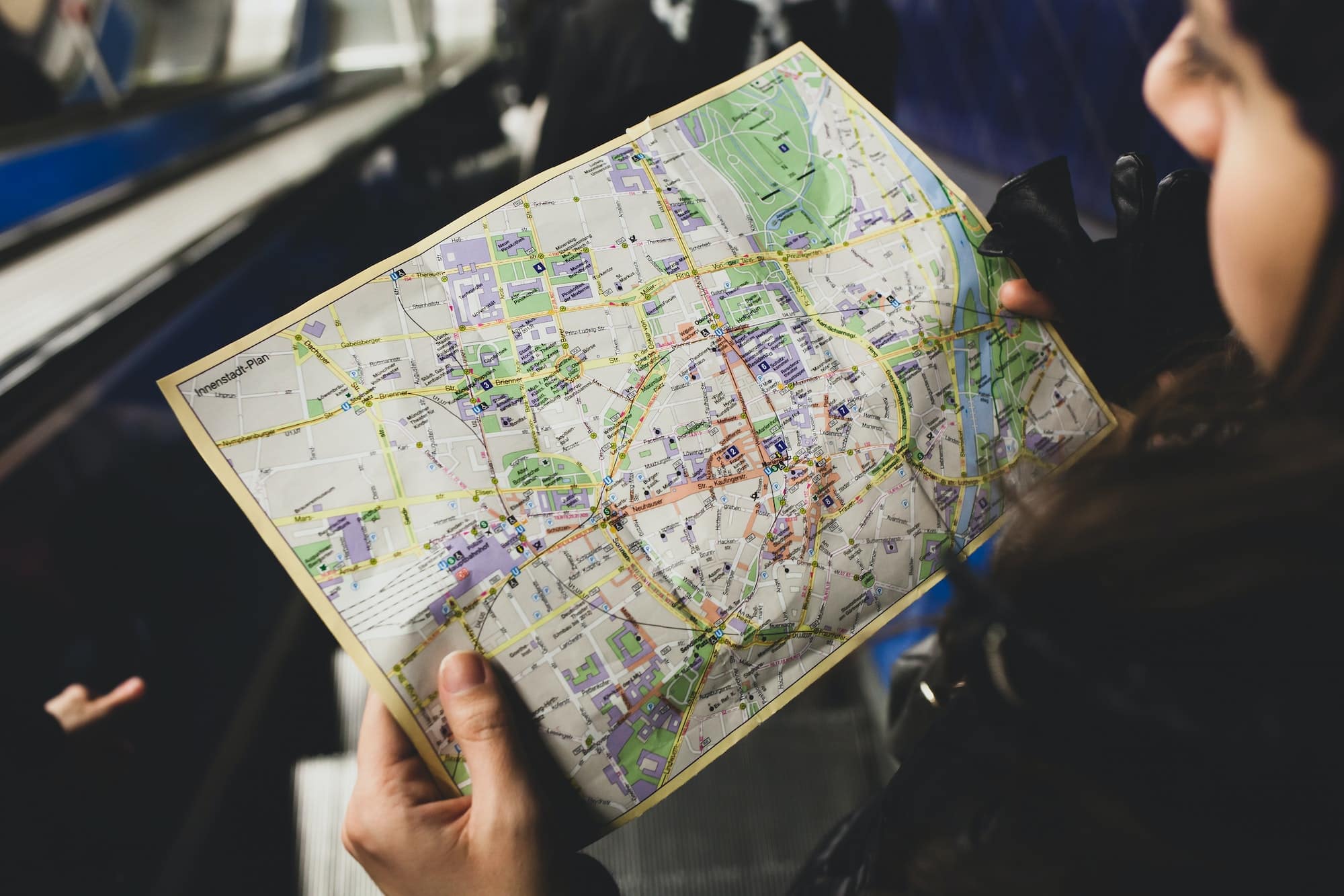 Young woman tourist studying the map of the city of Monaco of Bavaria in the subway.